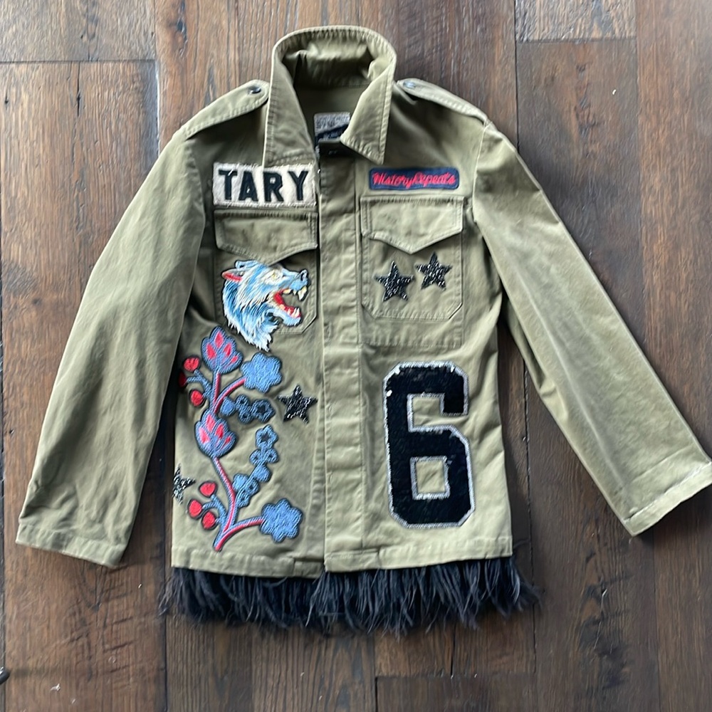 History Repeats army green jacket with patches and feathers.